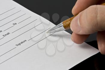 Man's hand signing the document