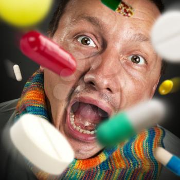 Various colorful pills falling into open mouth