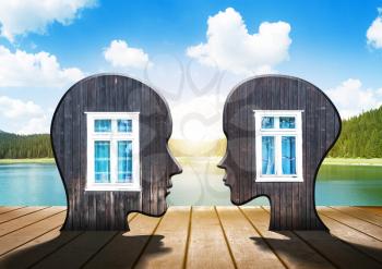 Two silhouettes of human head with windows inside on natural background