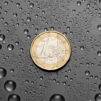 One EURO coin with water drops