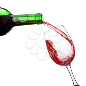 Red whine pouring into wineglass from bottle. Isolated