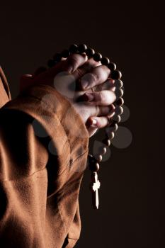 Monk in robe with two hands clasped in prayer