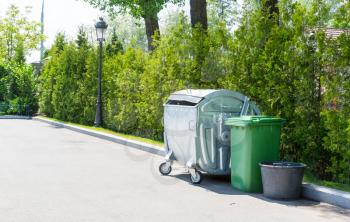 Metal and green plastic garbage cans in the yard