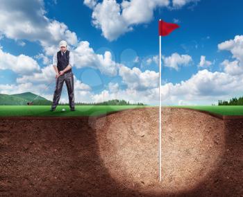 Businessman is hitting the golf ball to the huge hole