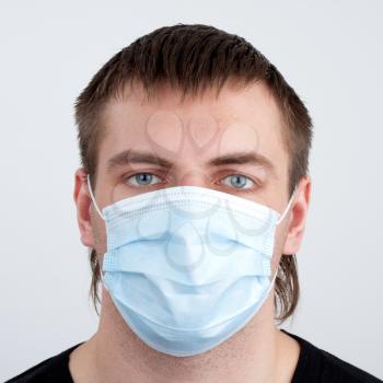 Portrait of pensive young man in medical mask