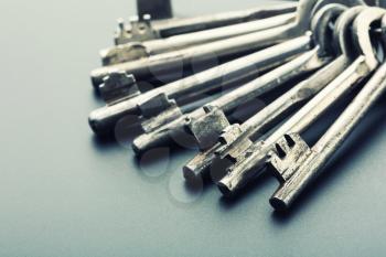 Bunch of old keys on grey background. Closeup view