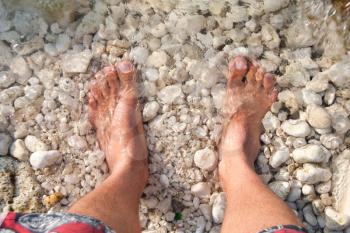 Man's legs in water on the seastones