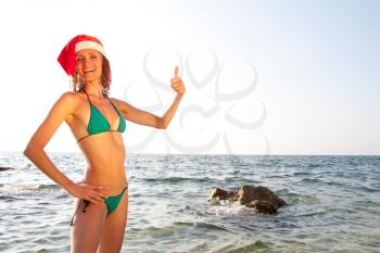 Tan woman in christmas hat showing OK sign