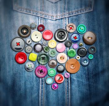 Many colorful buttons in heart shape on jeans cloth