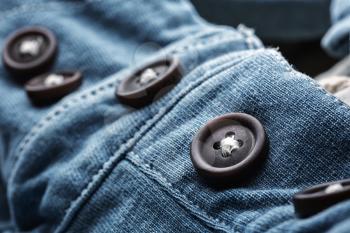 Closeup of jean cardigan with plastic buttons