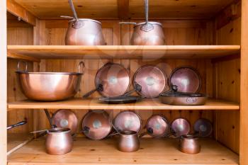 Set of vintage ibriks and pans on the wooden shelf