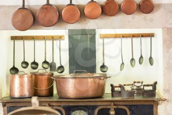 Retro kitchen interior with old pans, pot on the furnace closeup