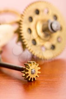 Various clock gears on the wooden table macro