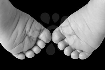 Close-up of newborn baby feet isolated on black