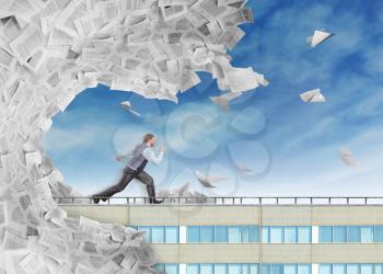 Businessman is running from big wave of paperwork
