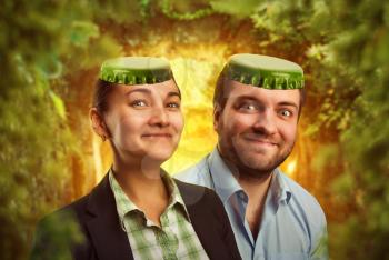 Man and woman with bottle caps on the head smiling