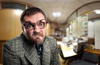 Angry businessman in glasses looking at you