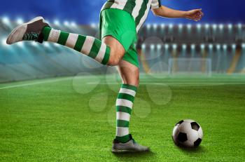 Football-player kicking the ball on the football ground