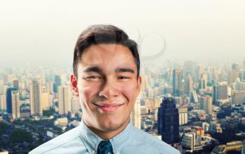 Smiling young businessman over the modern city