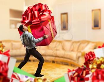 Businessman holding a big gift in the room