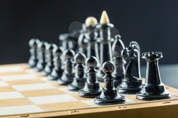 Black chess figures on the board ready to fight