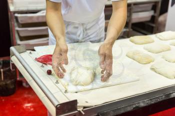 Baker working with dough in the bakery