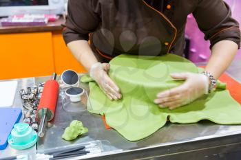 Baker hands decorating cake with gum paste 