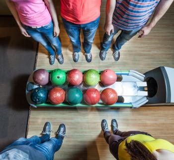 Up view of people in bowling standing near balls