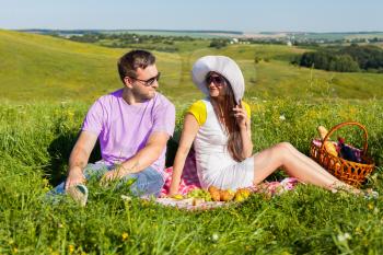 Young couple having picnic on the meadow