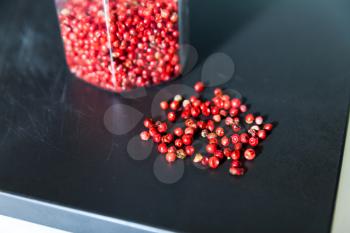 Dried red berries in glass jar and on the table