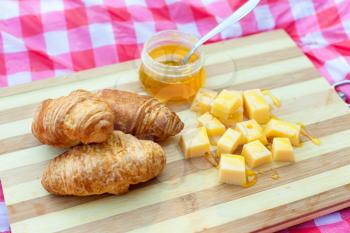 Croissants with cheese and honey on the board