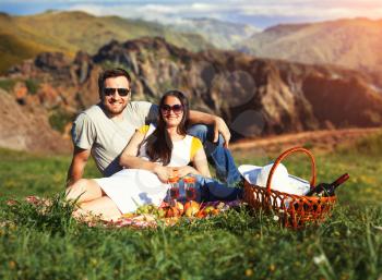 Young couple having picnic on the meadow