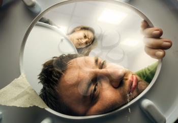 Man puking in the toilet bowl, woman is watching contemptuous