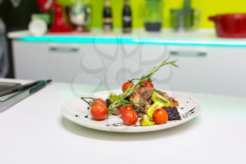 Tasty meat dish with vegetables stands on the table