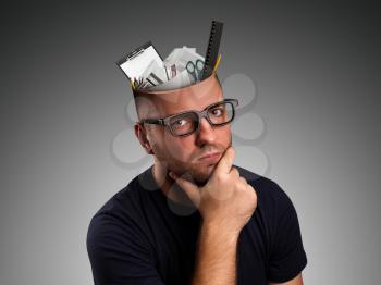 Pensive man with office details in the head over grey