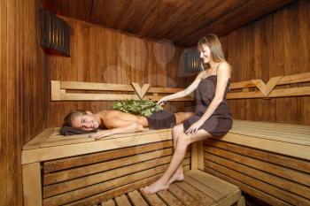 Two young females take a steam bath in a sauna.