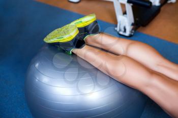 Close up og female legs on the rubber ball in the gym