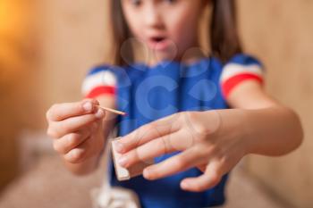 Little girl playing dangerous game with matches. Blur background.