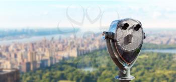 Observation deck with coin operated binocular. Blur cityscape on background.