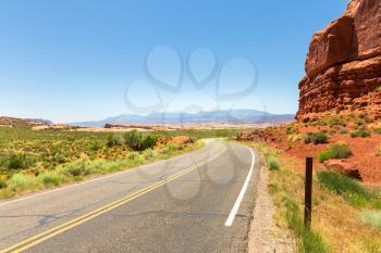 Desert road landscape with blue sky on background.
