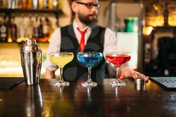 Bartender behind bar counter show alcohol coctails in restaurant