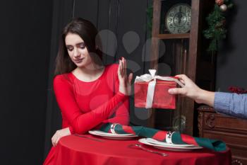 Shy woman refuses gift in restaurant. Couple relationship