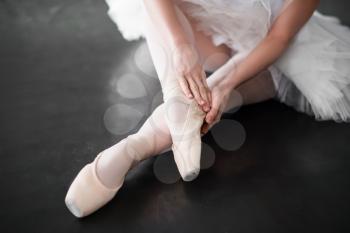 Ballet dancer legs in pointe shoes closeup. Ballerina rehearsal in class