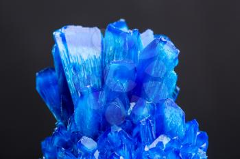 Blue salt crystal isolated on black background. Icy sulphate