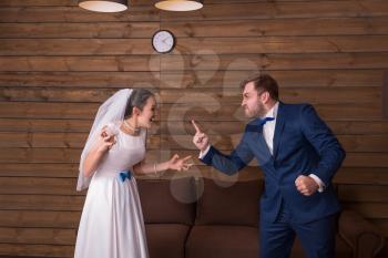 Bride and groom shouting at each other. Newlyweds complex relationship