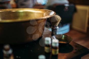 Copper bowl and shaving equipment on the table at barber shop. Hairdressing salon interior on background 