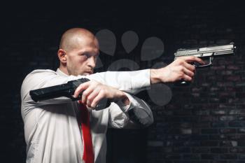 Serious hired assasin in red tie aims with two pistols. Professional secret agent concept. Murderer with guns, wallpaper, background or poster