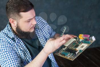 Service engineer fixing problem with pc hardware. Computer electronic components repairing technology