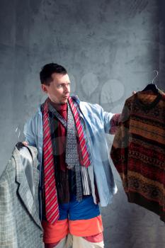 Man choosing clothes in clothing store. Shopping concept