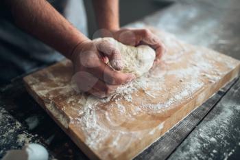 Baker hands kneading the dough with flour. Bread preparation. Homemade bakery